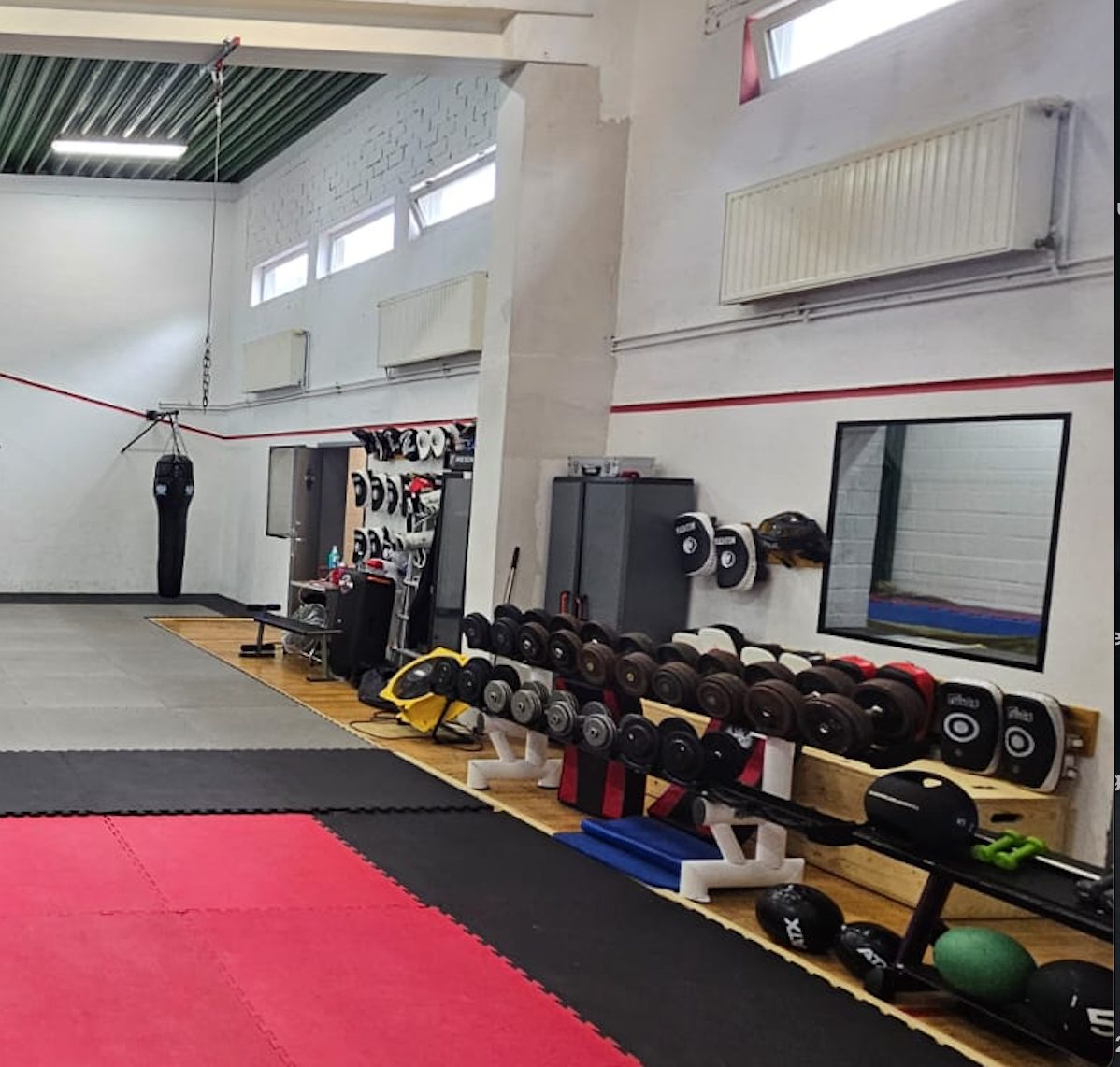 Trainingshalle mit Matten und Hantelbereich